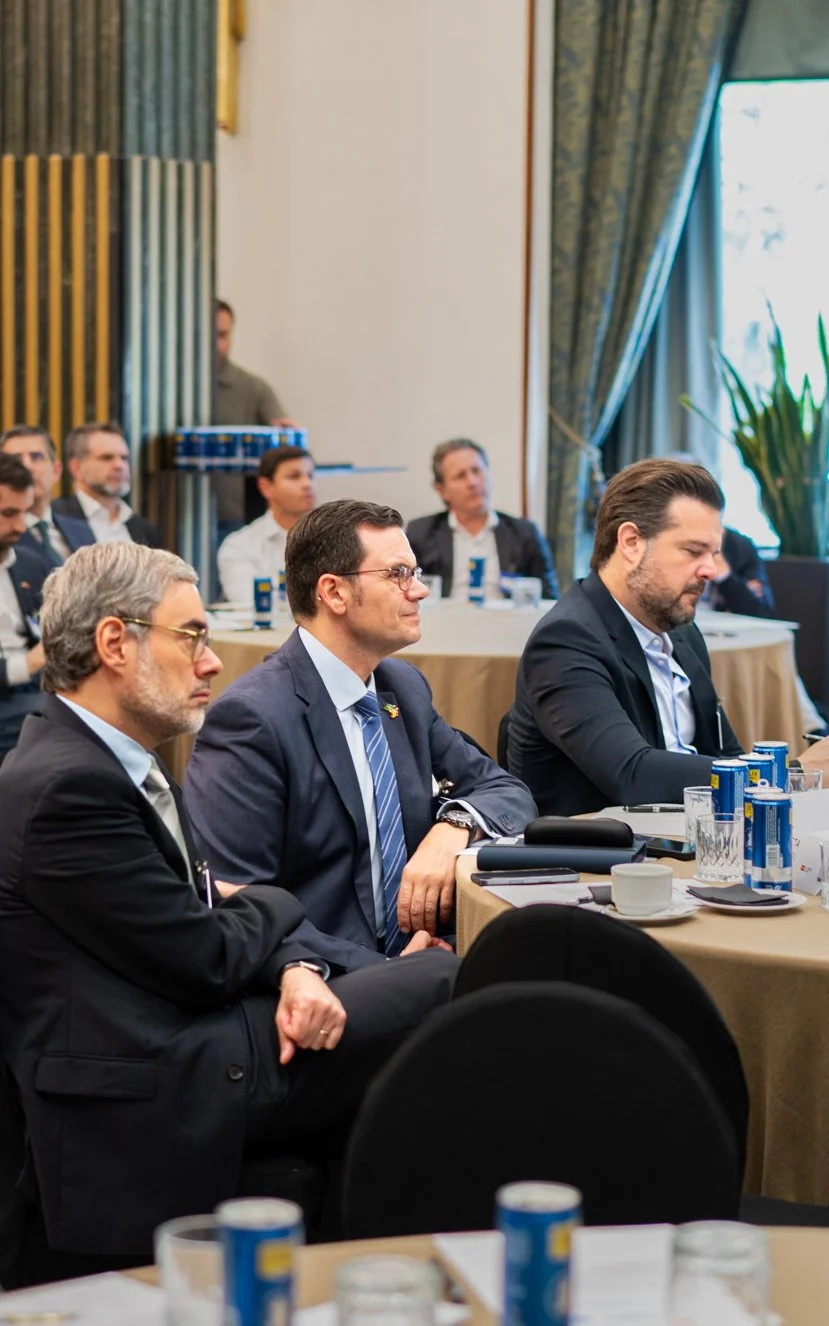 Reunión de varias personas en una conferencia o seminario, espectadores sentados escuchando, con una mesa con bebidas y objetos de oficina.