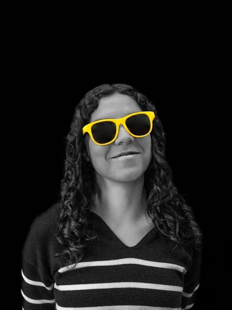 a woman in a black and white photo with yellow glasses