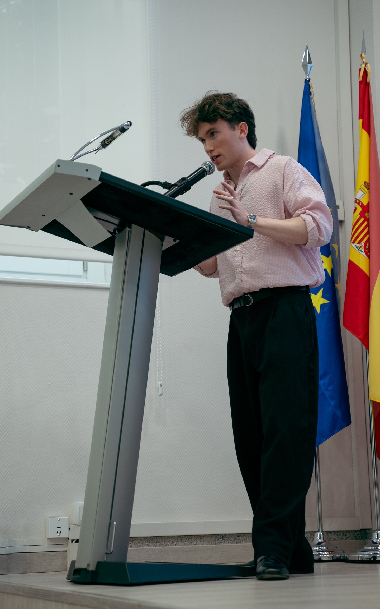 Liam en el atril, con las banderas de la UE y España al fondo, dándo el discurso de apertura de SEO a GEO en Madrid.