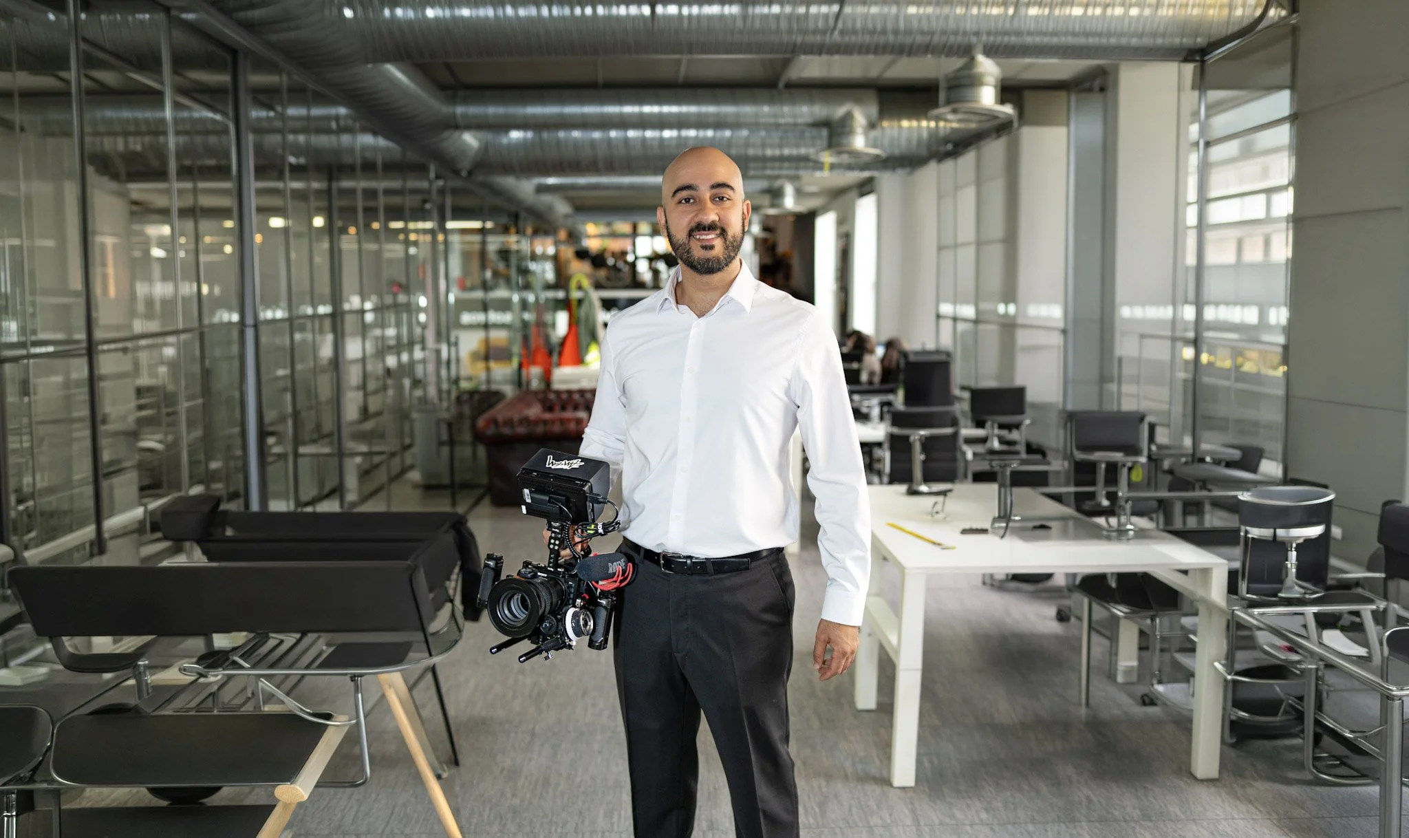 A filmmaker with a professional camera in a corporate office.