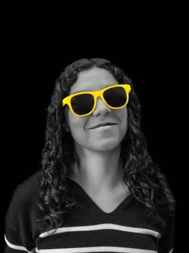 a woman in a black and white photo with yellow glasses