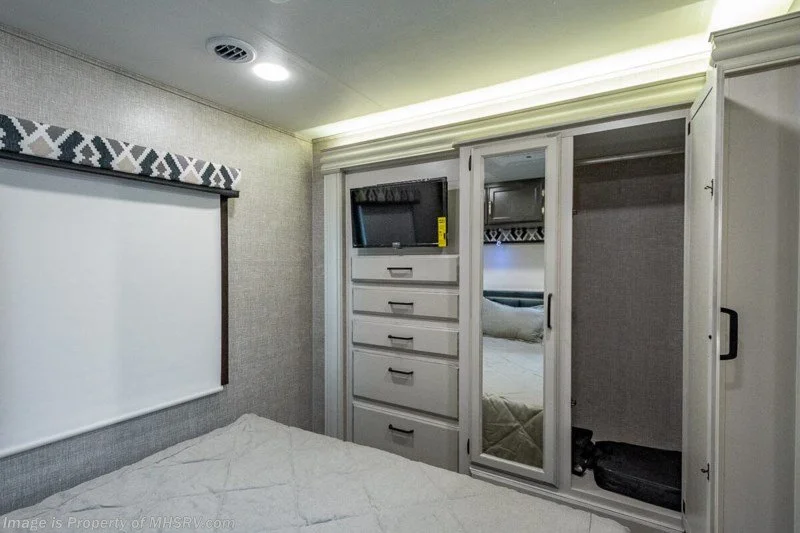 Bedroom with closet, drawers, and TV