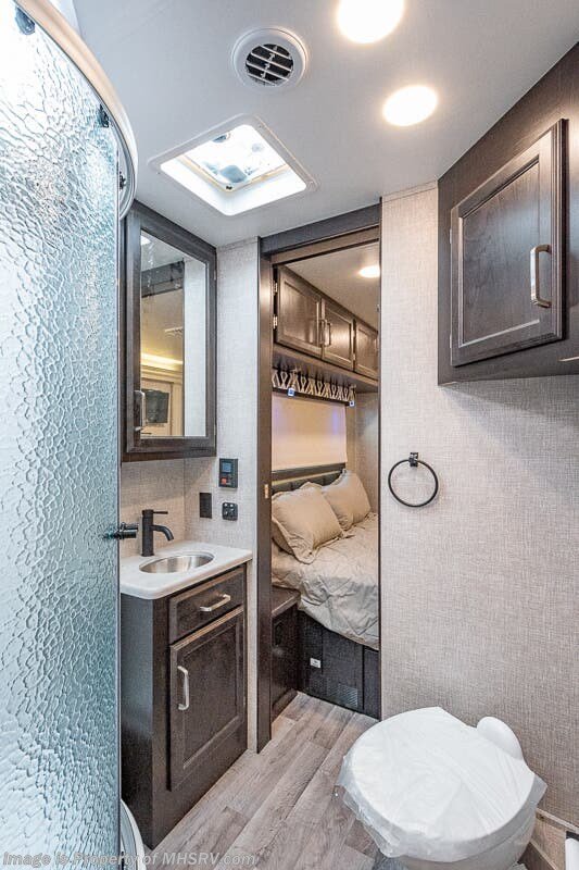 Bathroom with toilet, sink, and radius shower