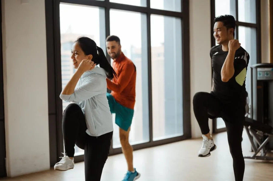 Group of three people attending cardio class at a gym