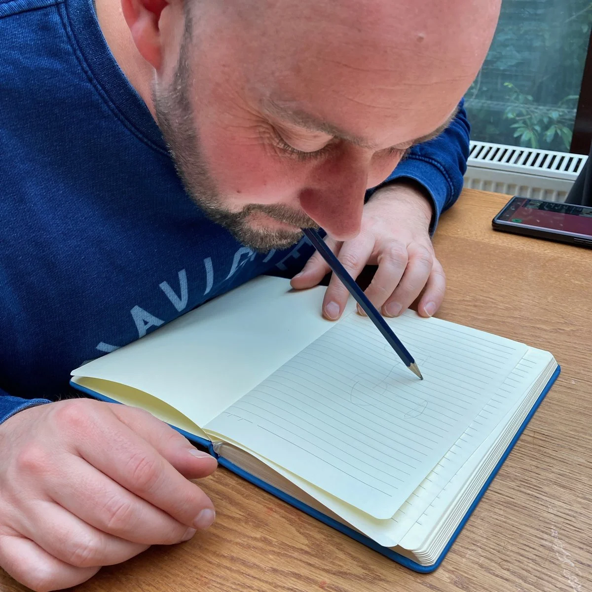 Shan of Yoshan drawing using a pencil in his mouth