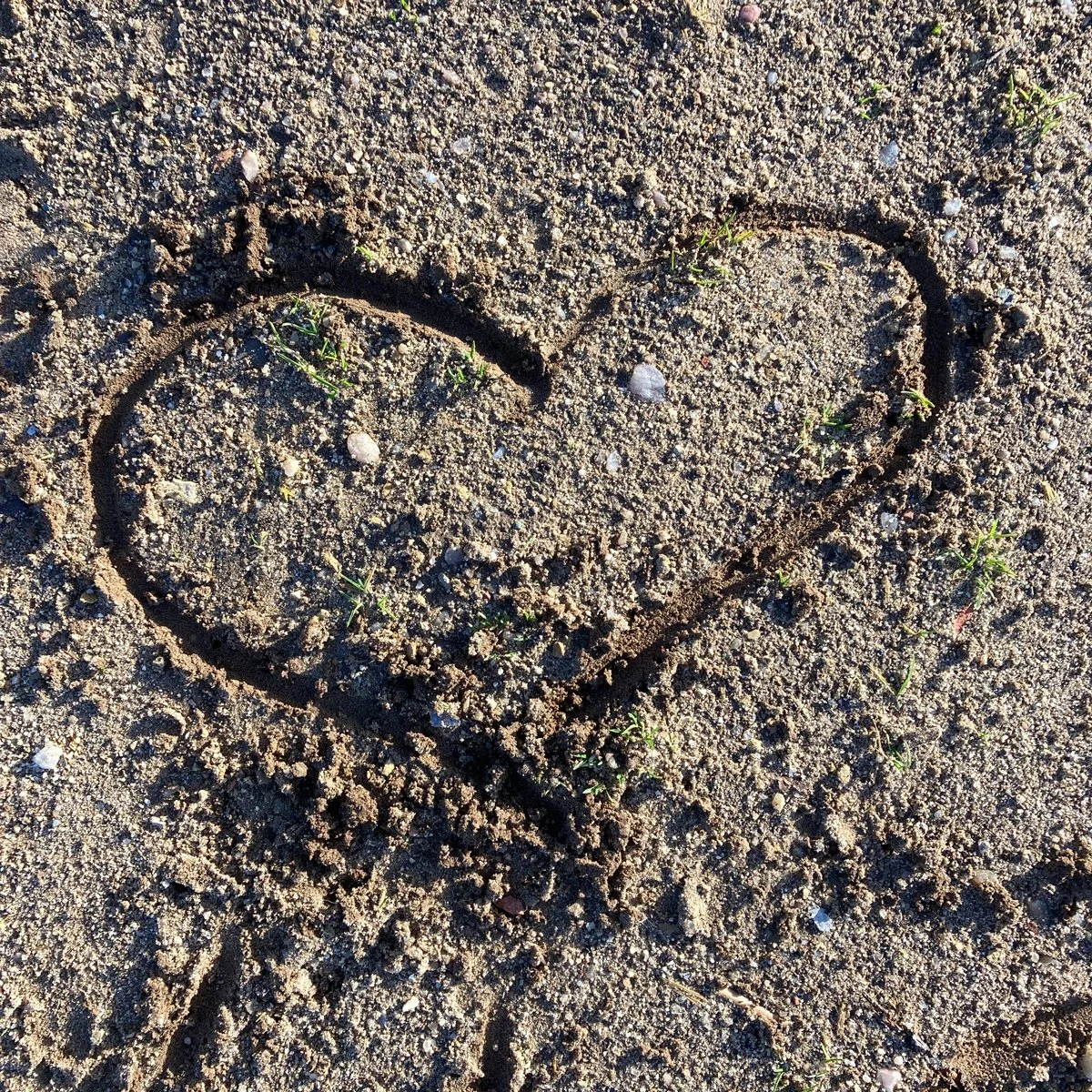 Photo of a heart drawn in sand