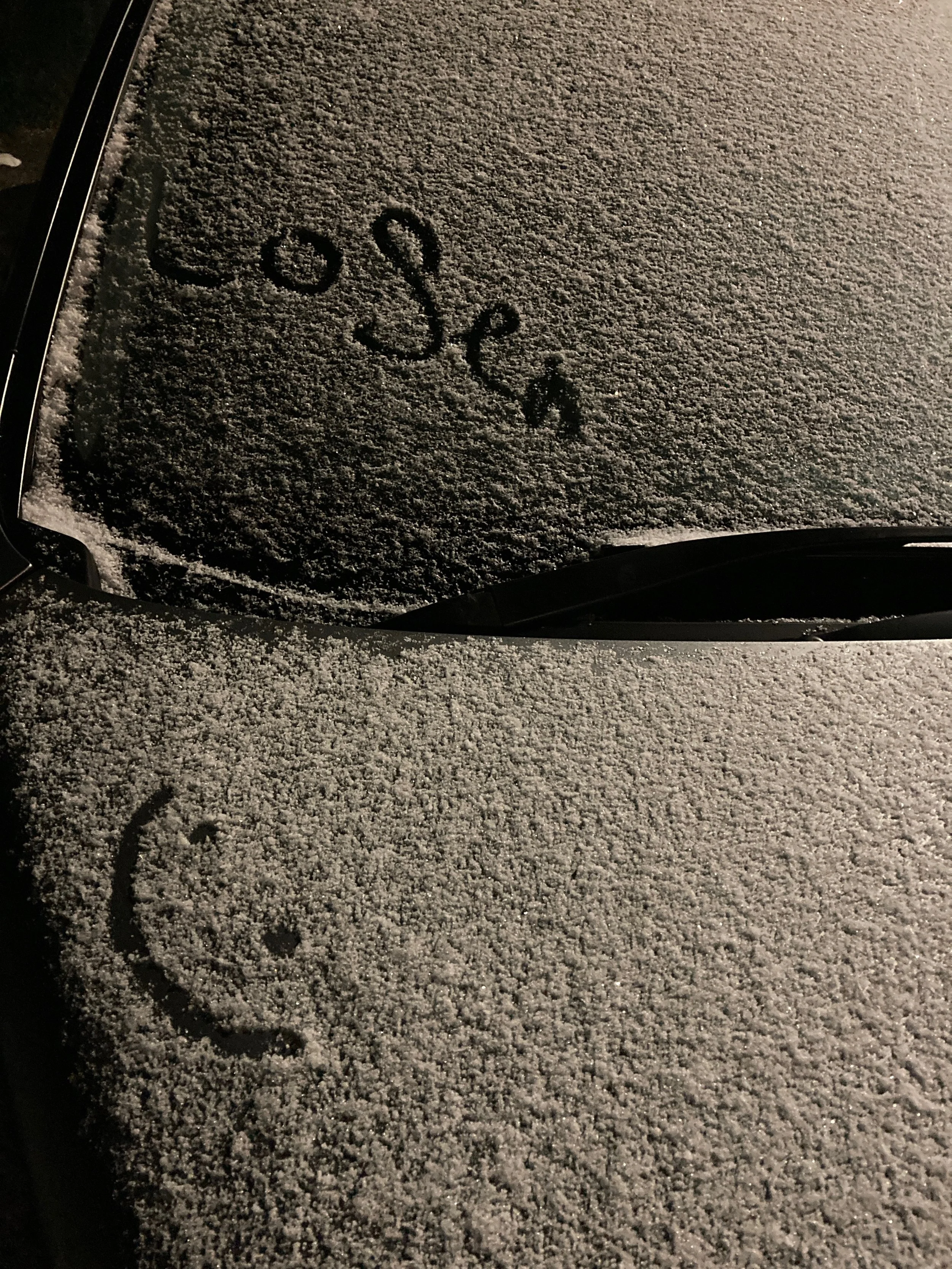 Photo of a car covered in snow with the word loser drawn on it and a smiley face