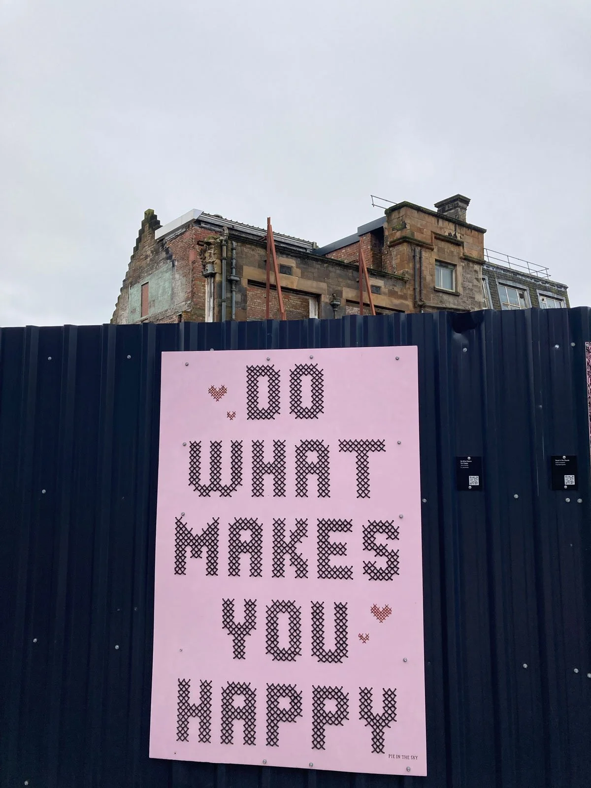 Outdoor poster, do what makes you happy with building in background