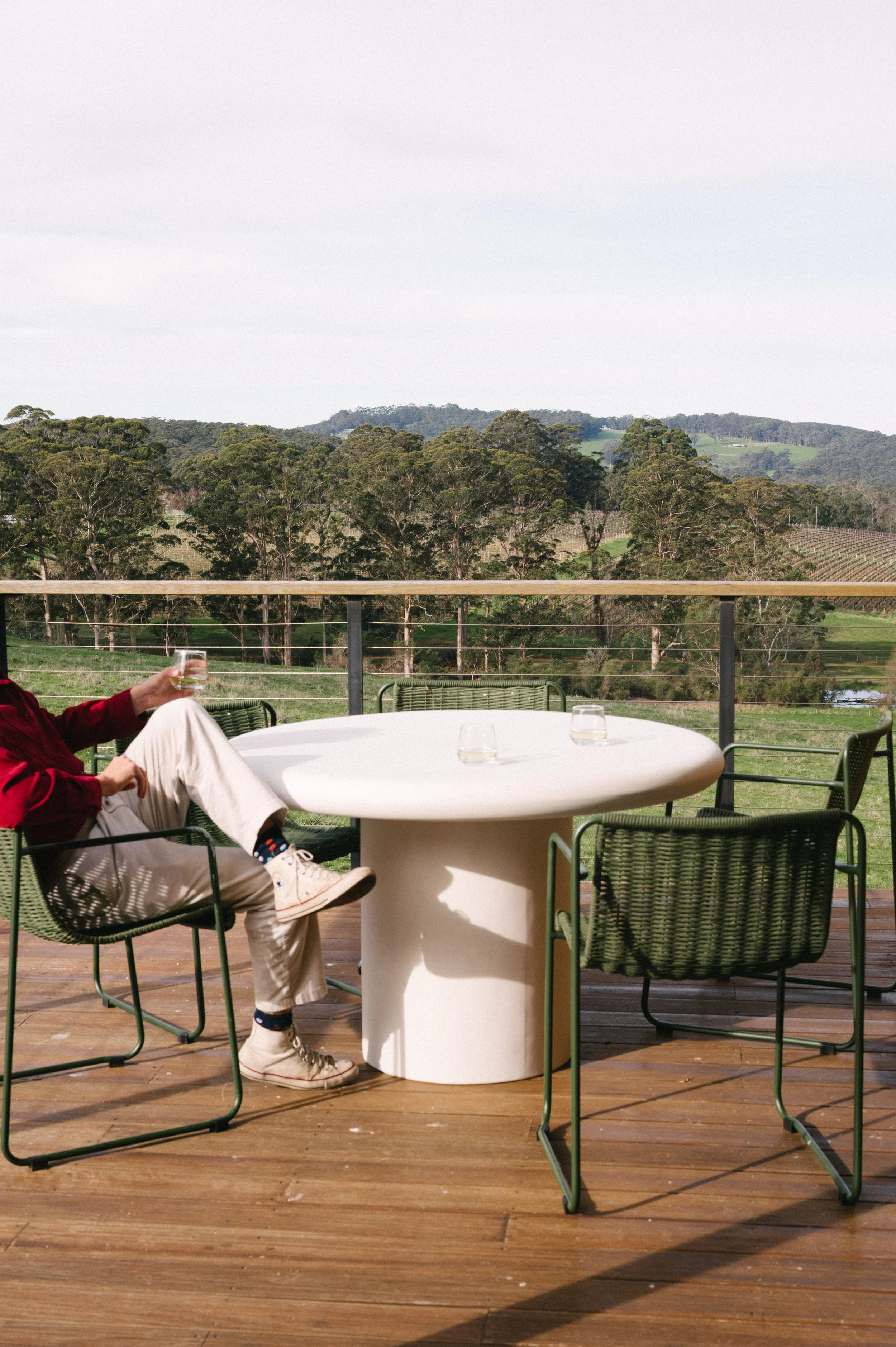 A man relaxing with a glass of wine on the private deck of Cabin Vine at Upland Farm in Denmark, Western Australia.