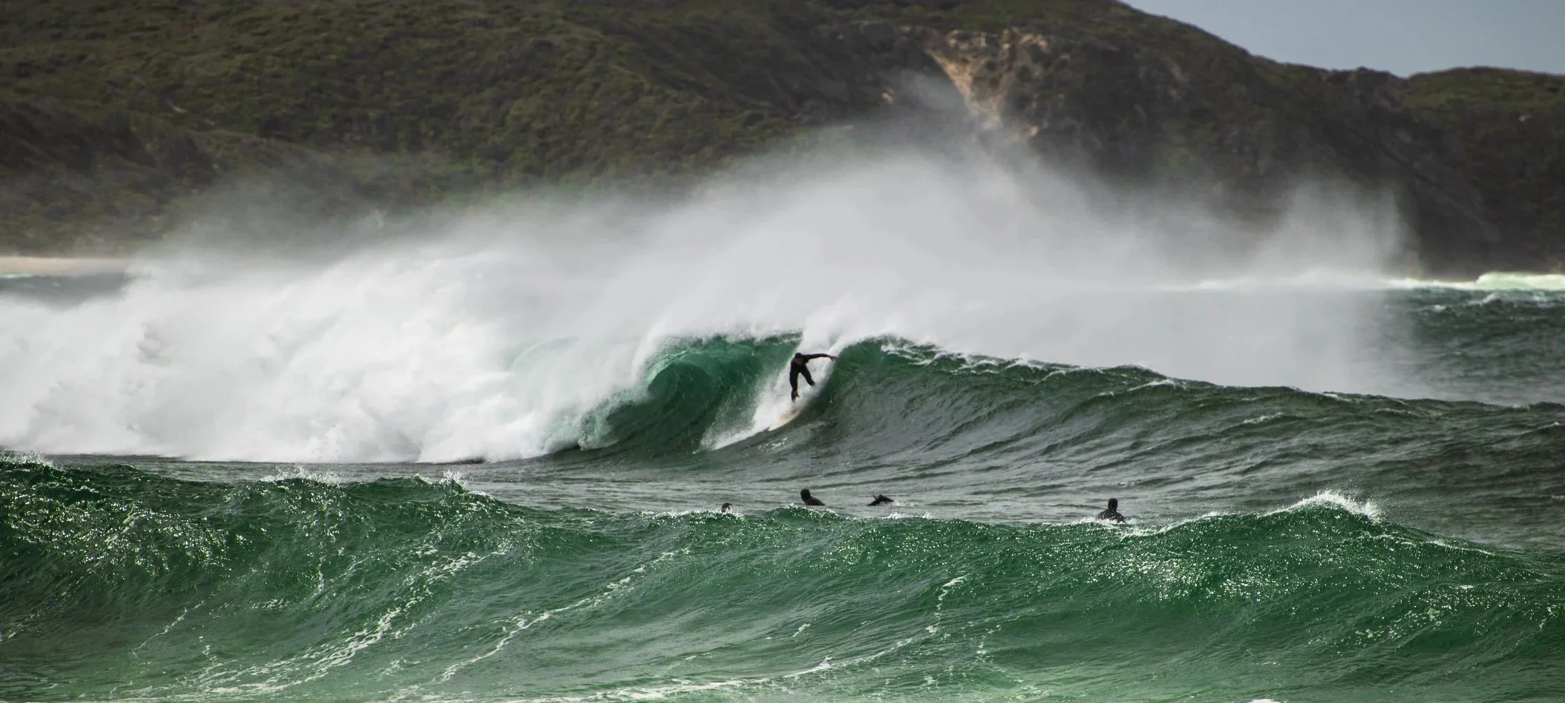 Surfers riding waves at Ocean Beach in Denmark Western Australia during coastal swell conditions.