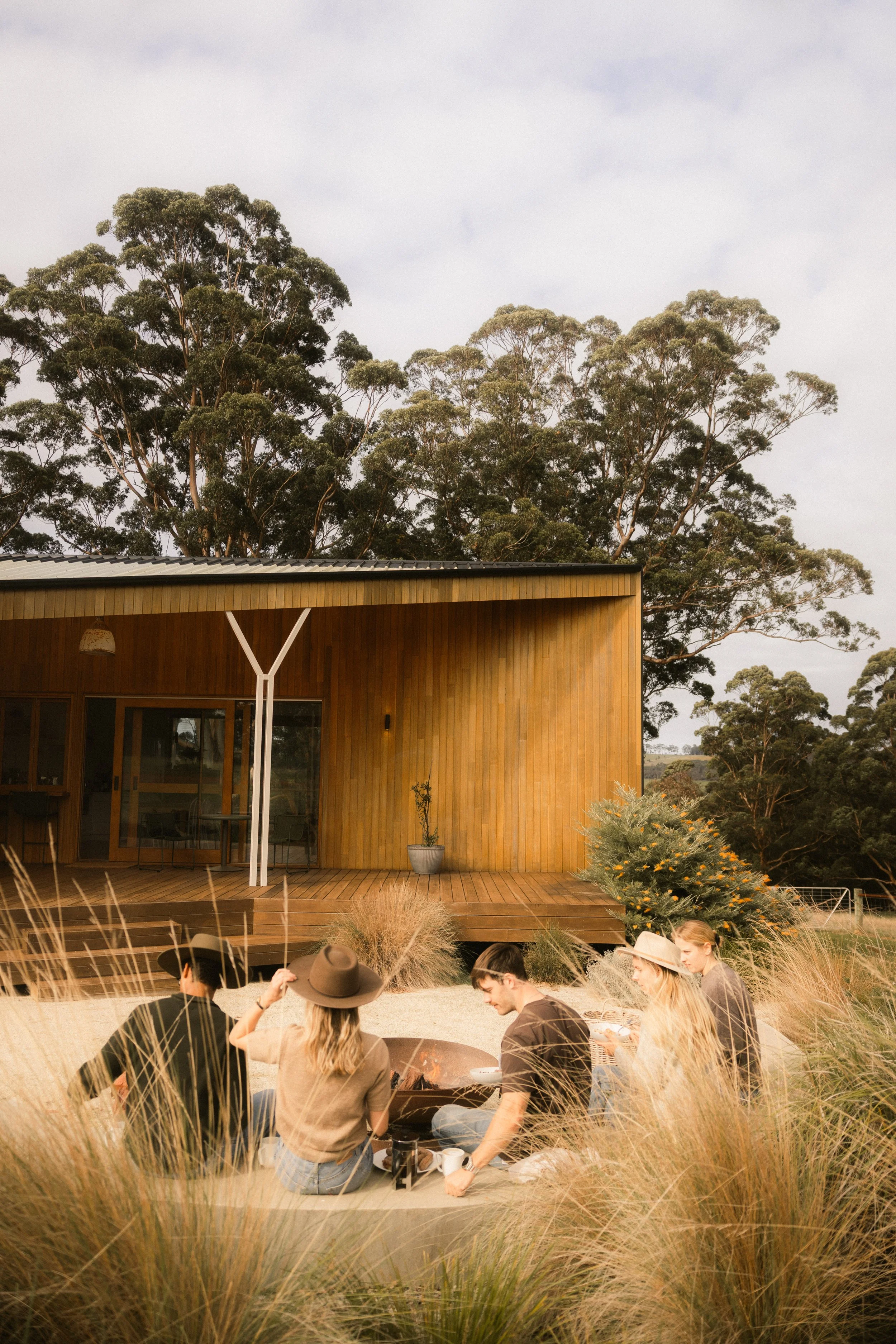 A group of guests enjoying time together in the gardens at Upland Farm, surrounded by the peaceful countryside of Denmark, Western Australia.