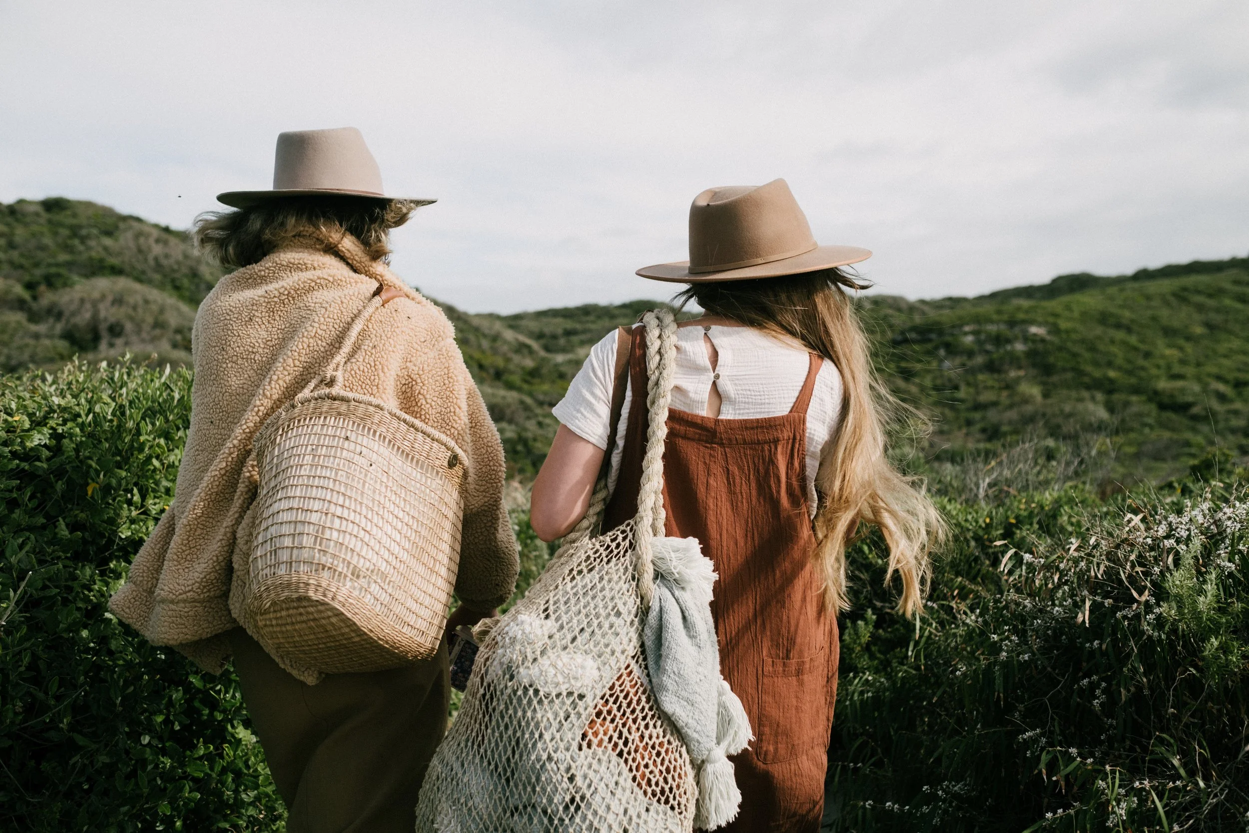 Two women walking along a wildflower trail in Denmark WA surrounded by native bushland.