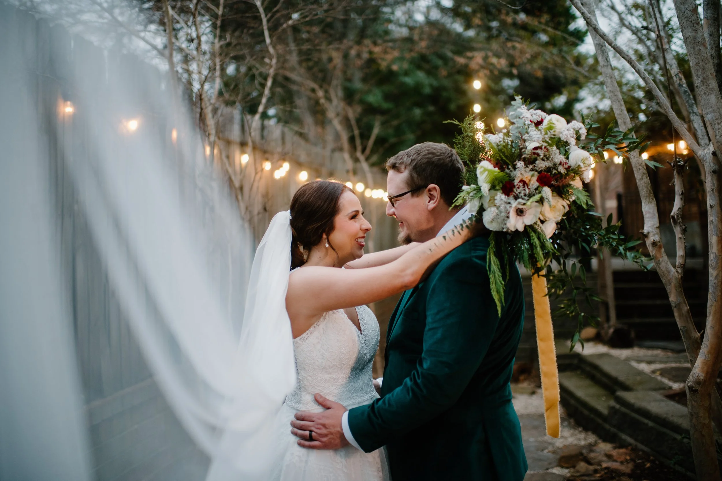 Bride and Groom, bride holding a bouquet of flowers designed for a Christmas wedding 