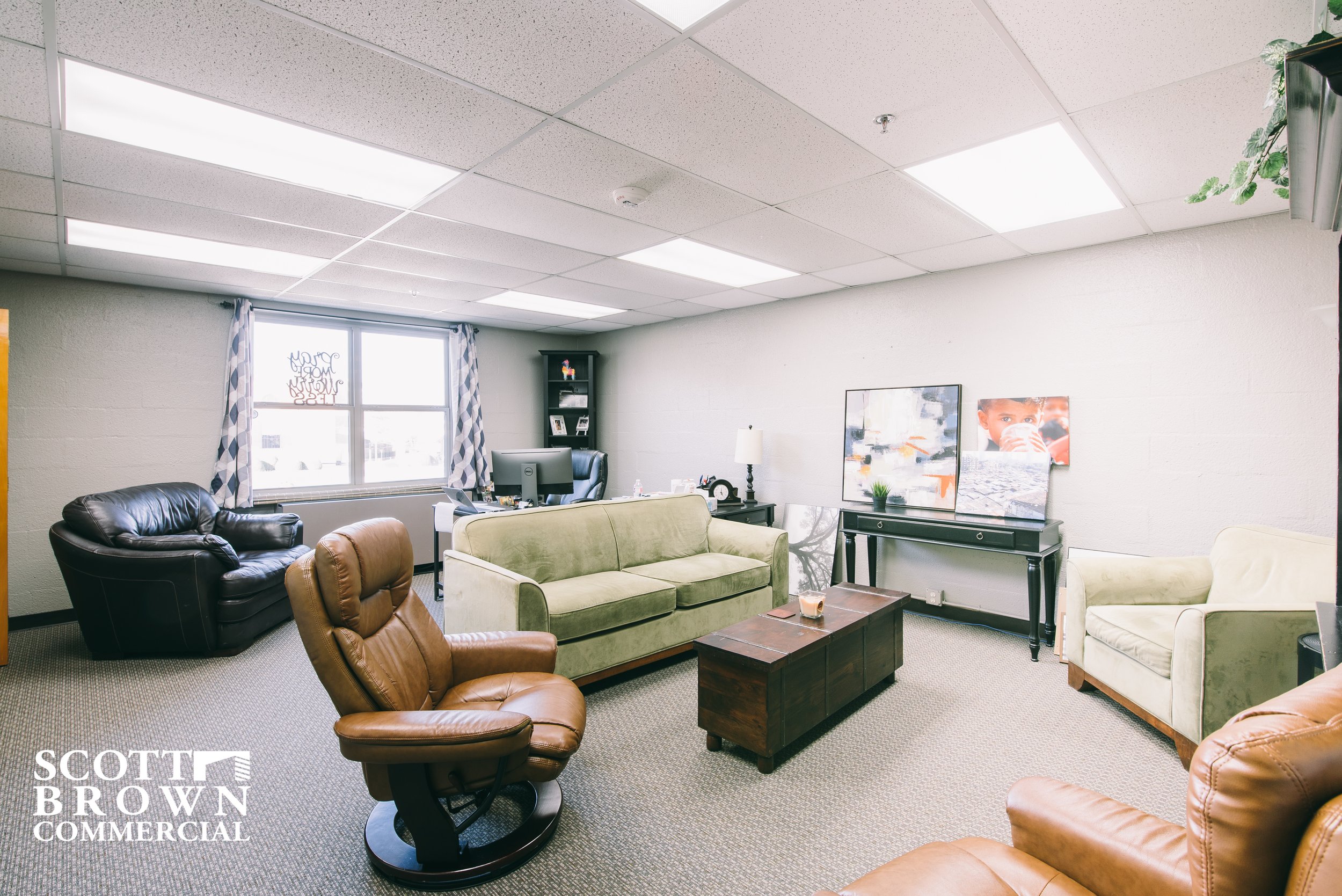  a seating room with tan, cream, and black couches 