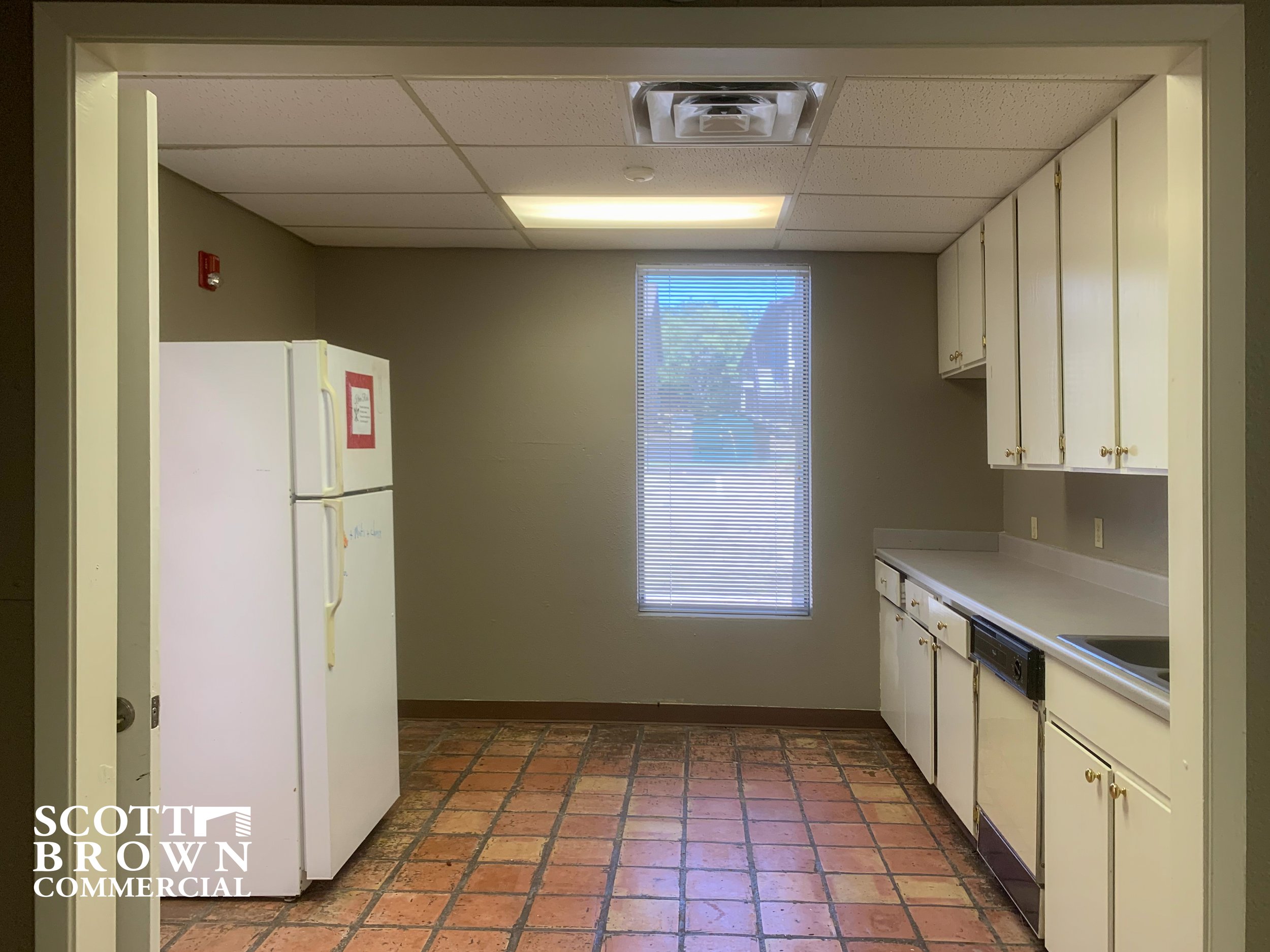  400 S Carroll Boulevard’s break room kitchen with tile floors, sink, and fridge 