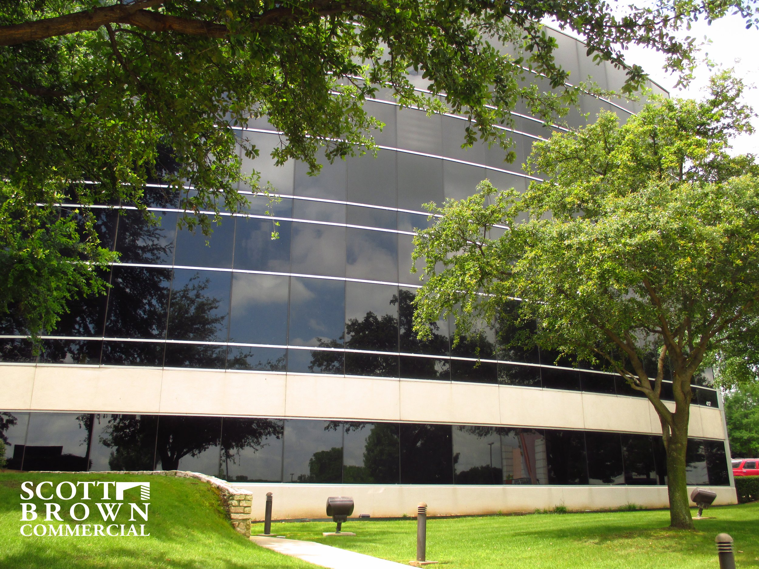  side of the sleek building at 417 Oakbend Drive with a lot of windows 