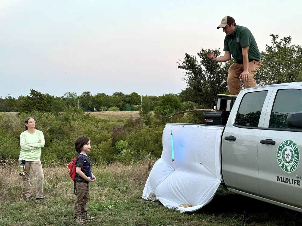  One of our summer interns, Paige, looks on as Sam engages a young naturalist. 