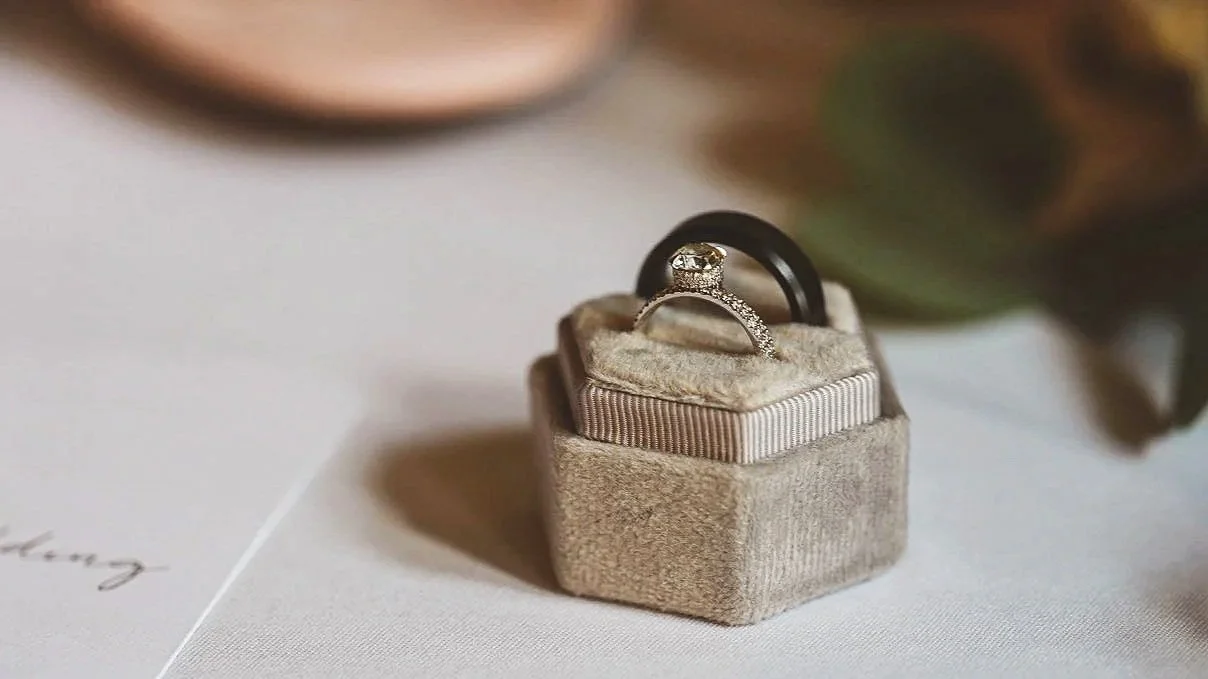 Wedding rings displayed in a ring box on soft fabric