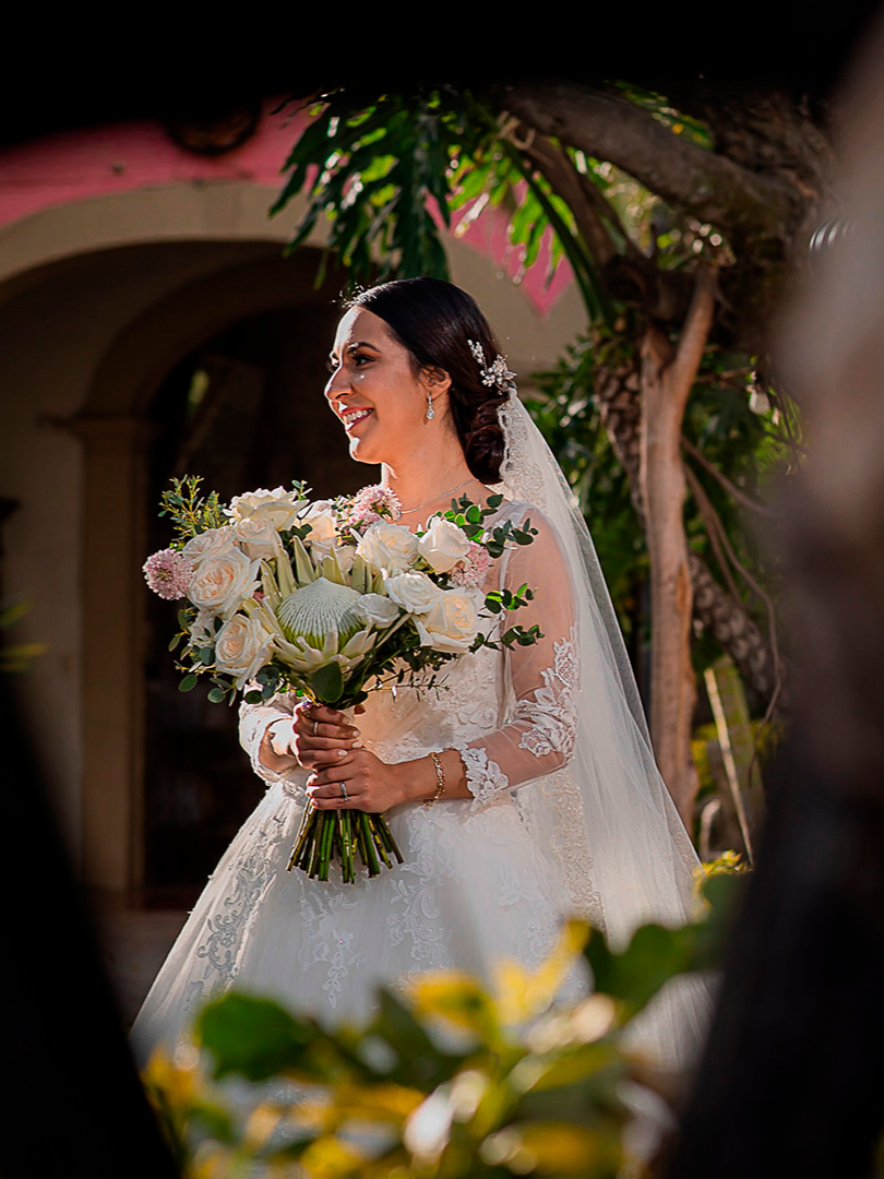 Smiling bride holding a white floral bouquet on her wedding day