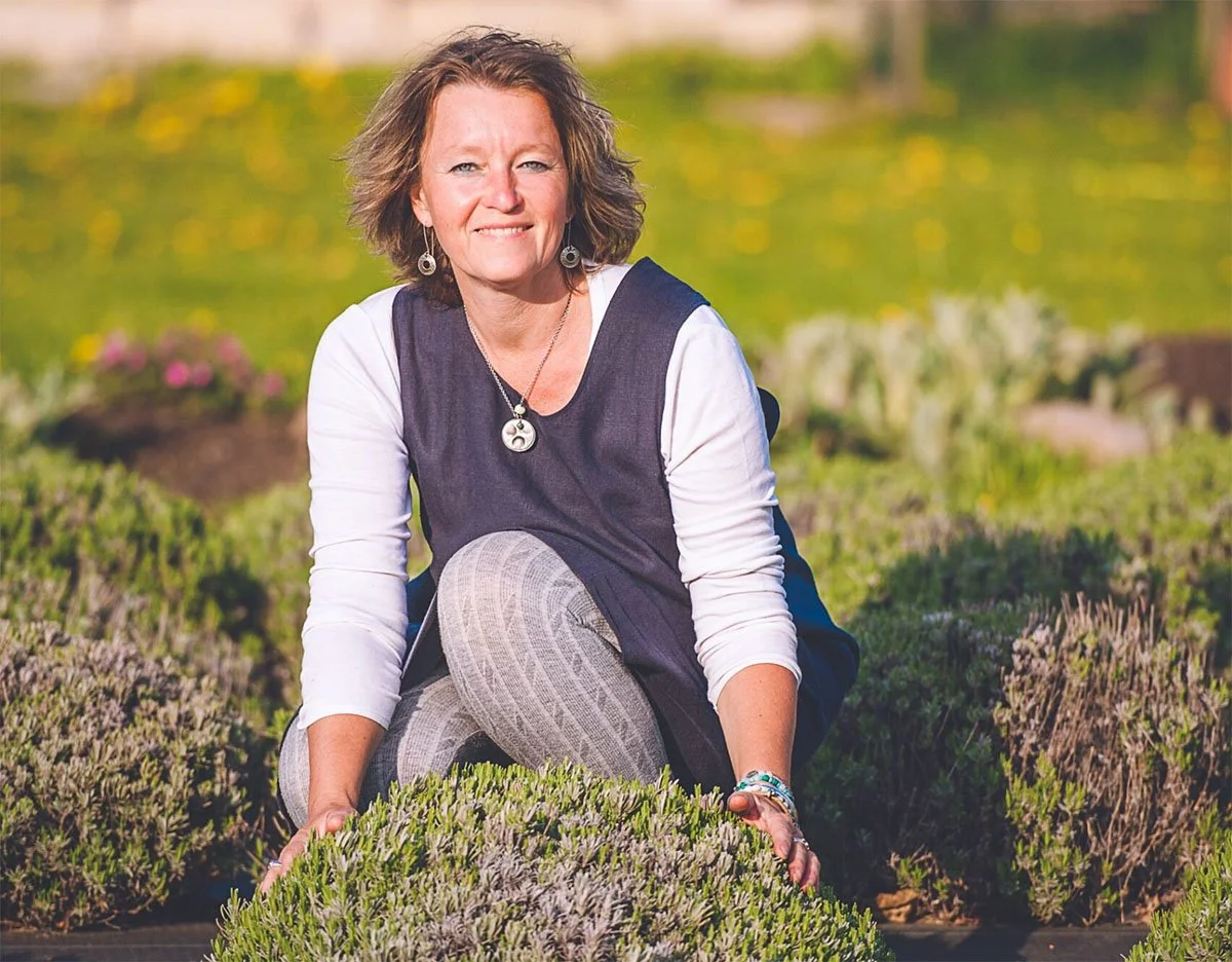 Mila Haynos of Lavender-Blu sitting in a field of lavender promoting her Educational Eco Garden Tour for Small Town Big