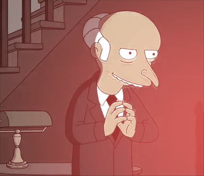 A cartoon character known as Mr.Burns with a long nose and a suit, smiling mischievously in a dimly lit room with stairs in the background.