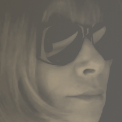 Close-up of a woman, Anna Wintour, wearing large sunglasses with side-swept hair.