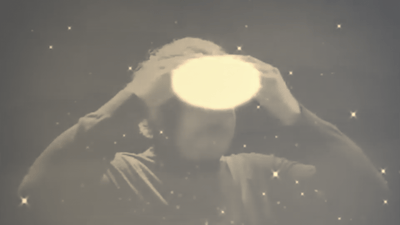 Person holding a glowing object over their head with sparkles and star effects