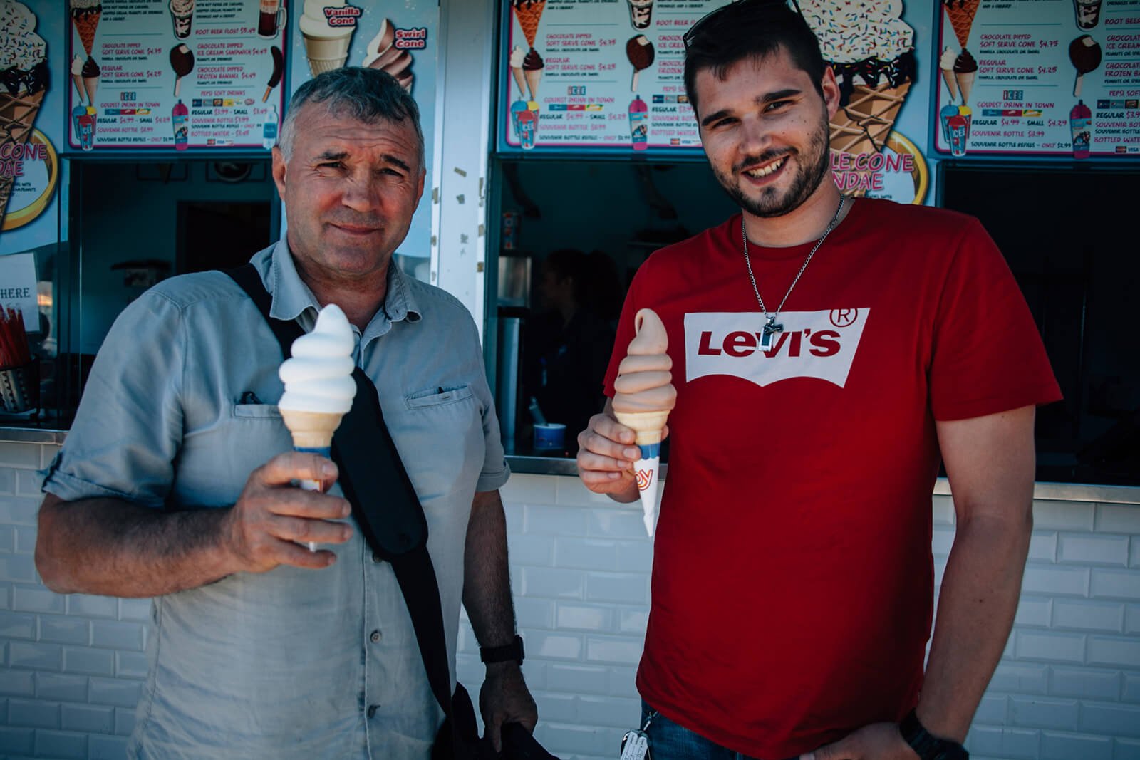 Father and son holding ice cream near the beach in New England