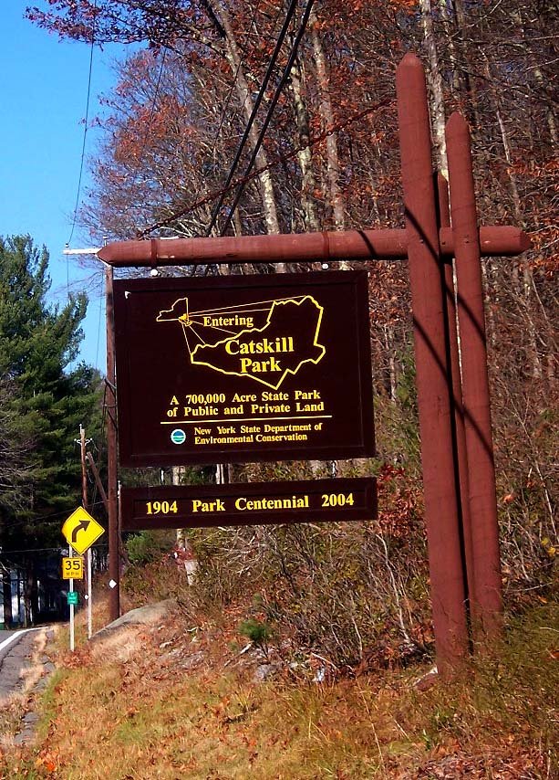 Signboard for Catskill Park, a 700,000-acre state park in New York, showing the years 1904 and 2004 for its centennial, and indicating it is managed by the New York State Department of Environmental Conservation.