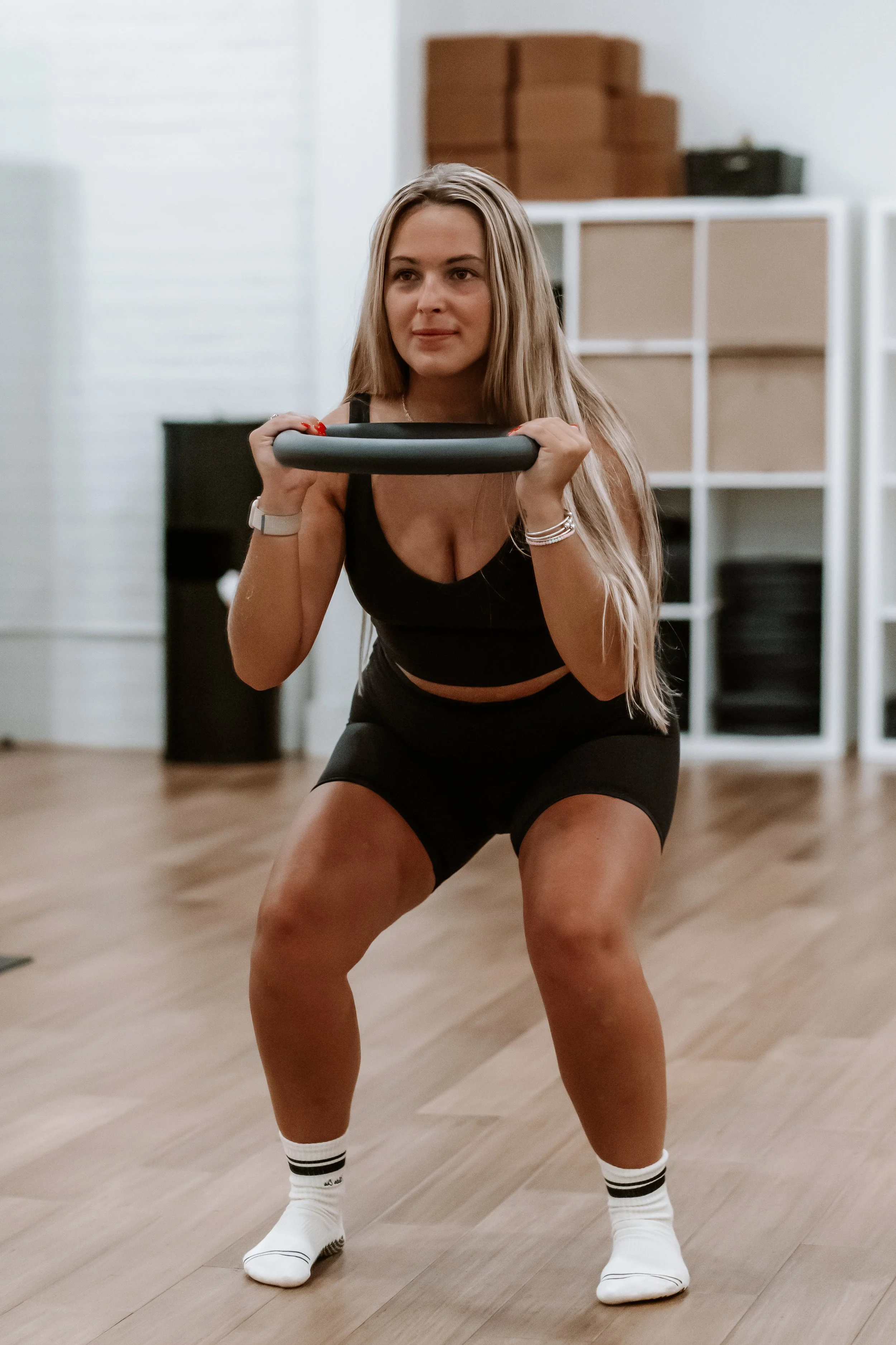Woman strength training with Pilates ring