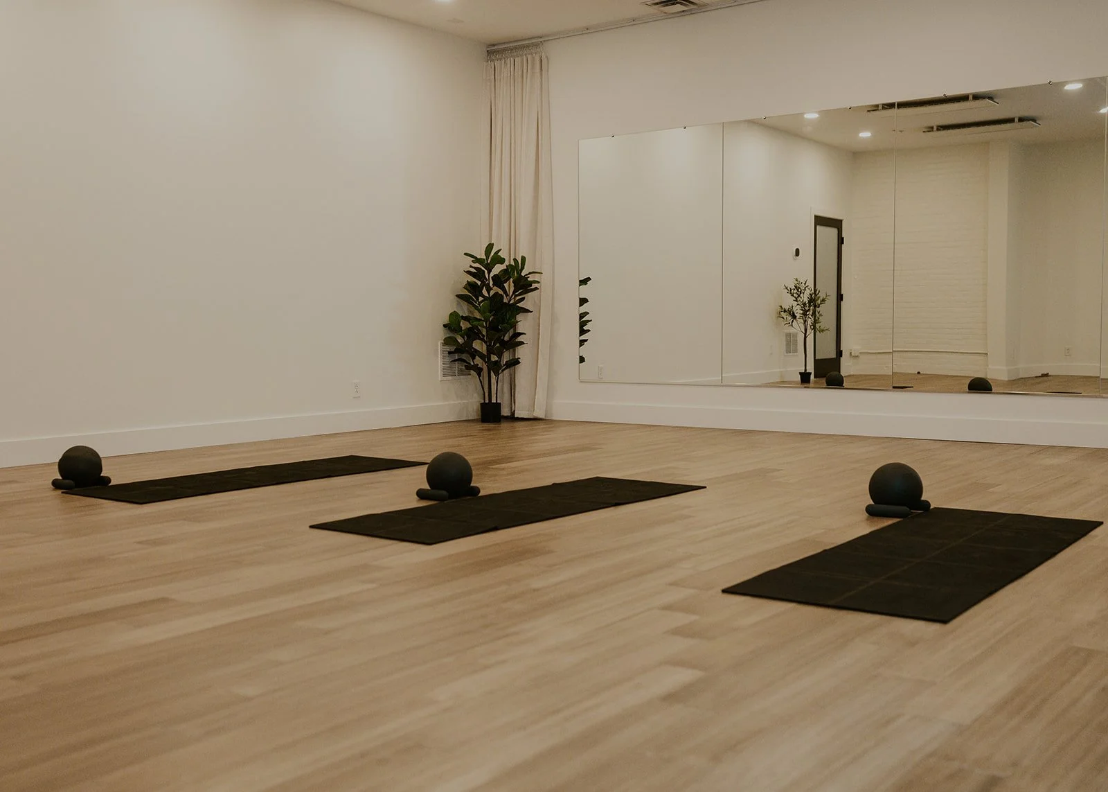 Three mats and Pilates balls in empty studio