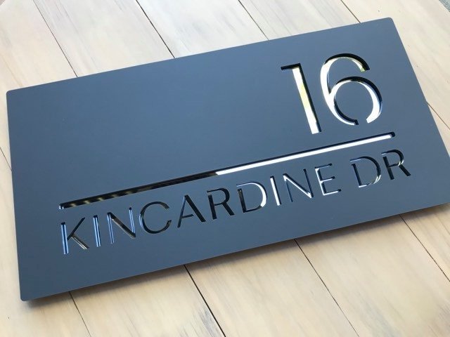 Mid grey sign with reflective mirror letters
