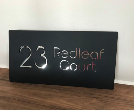 Black sign with reflective mirror letters