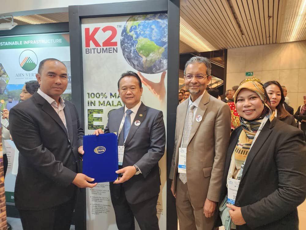  K2 Bitumen Sdn Bhd’s Managing Director, Encik Mohamed Nasser bin Ahmad, (left) a pavilion partner receiving the certificate of appreciation from the Minister of Works.&nbsp; 