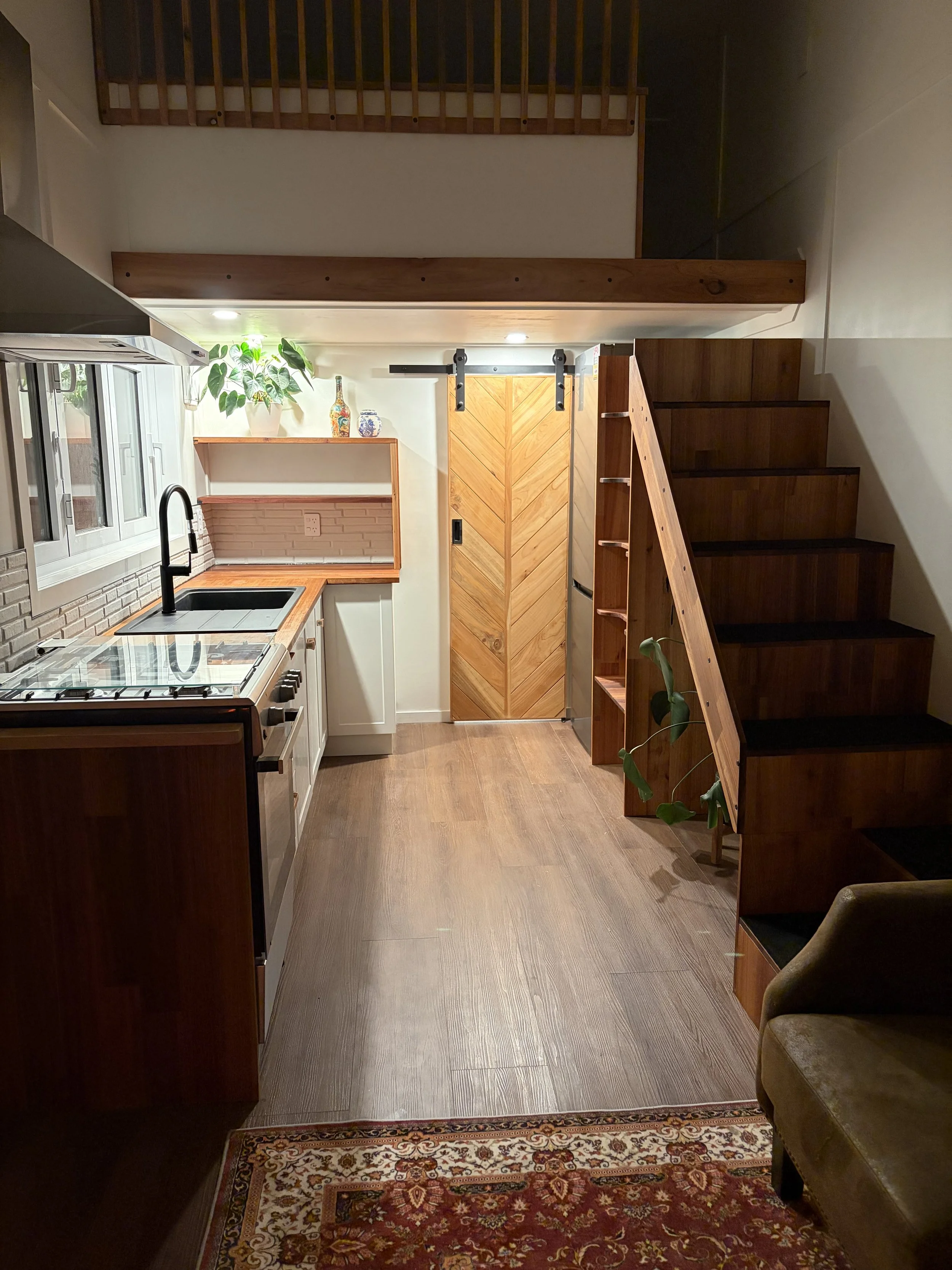 Tiny Timber Homes rental kitchen and timber staircase in evening light