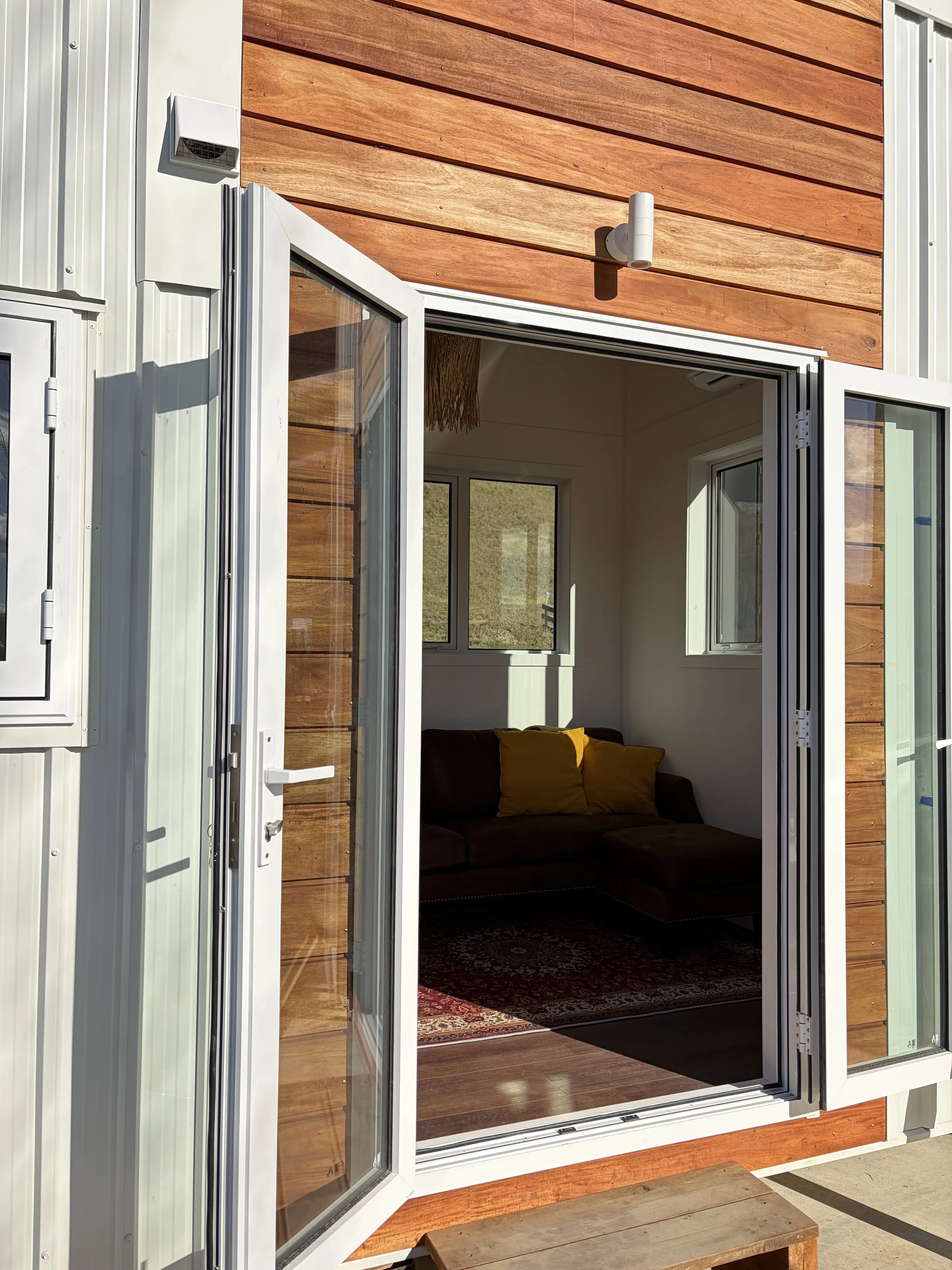 Tiny Timber Homes rental exterior with open bifold doors leading into the lounge