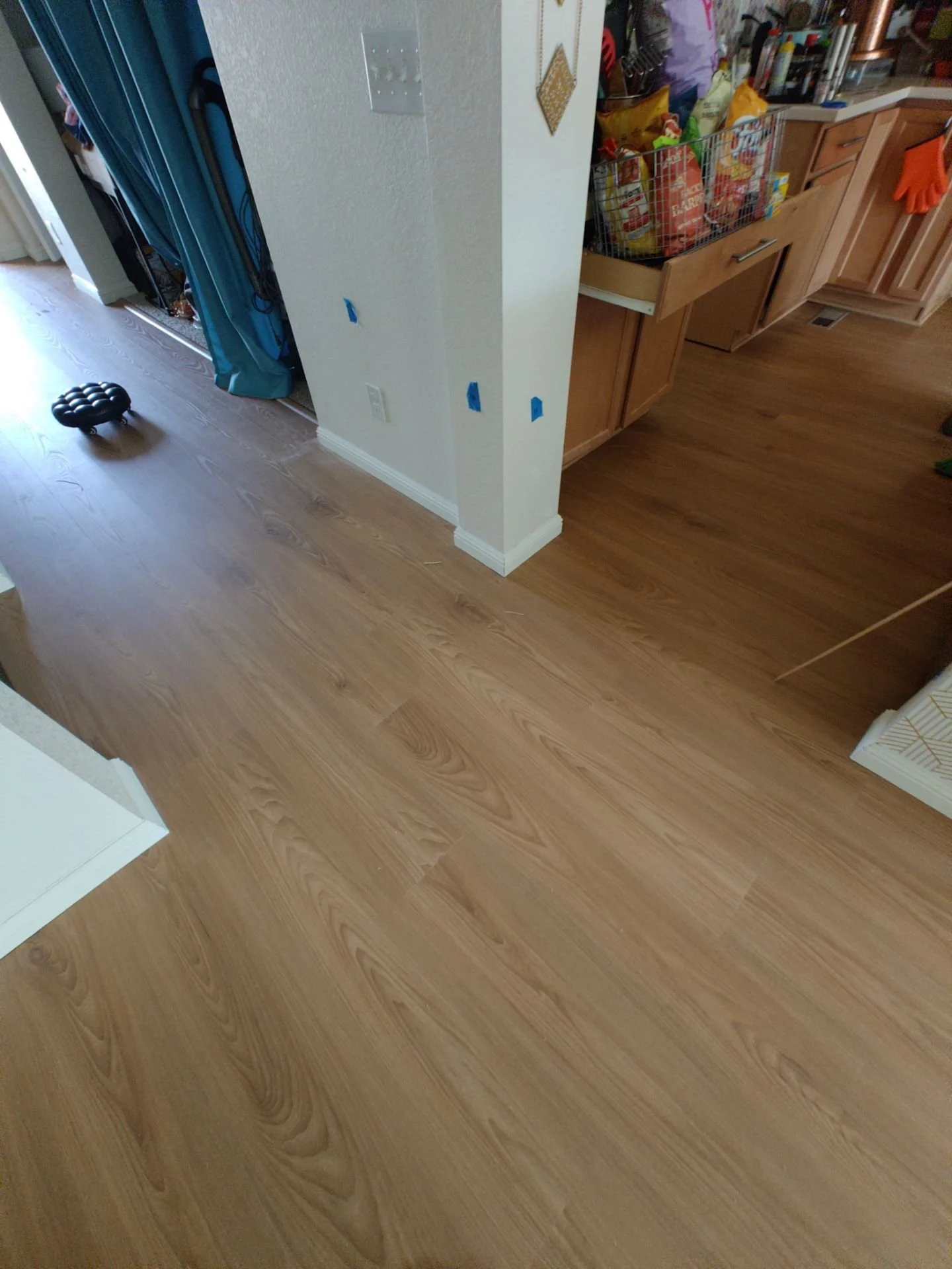 Before and after of luxury vinyl plank flooring installation over approximately 650 square feet in Broomfield, Colorado.