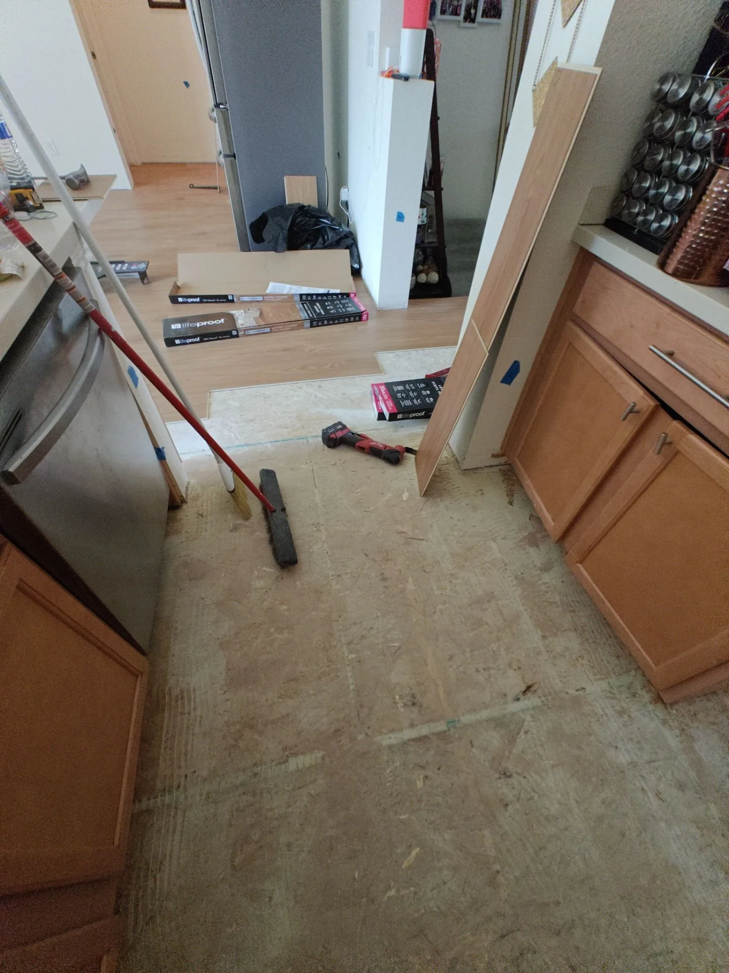 Wide view of completed LVP flooring installation connecting the kitchen and living area in Broomfield.