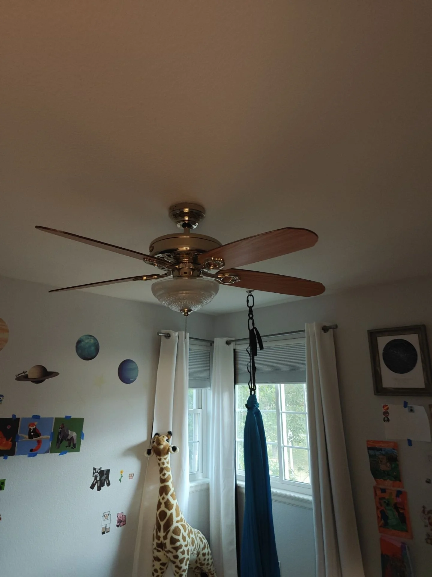Old ceiling fan being removed and replaced during a professional ceiling fan installation service