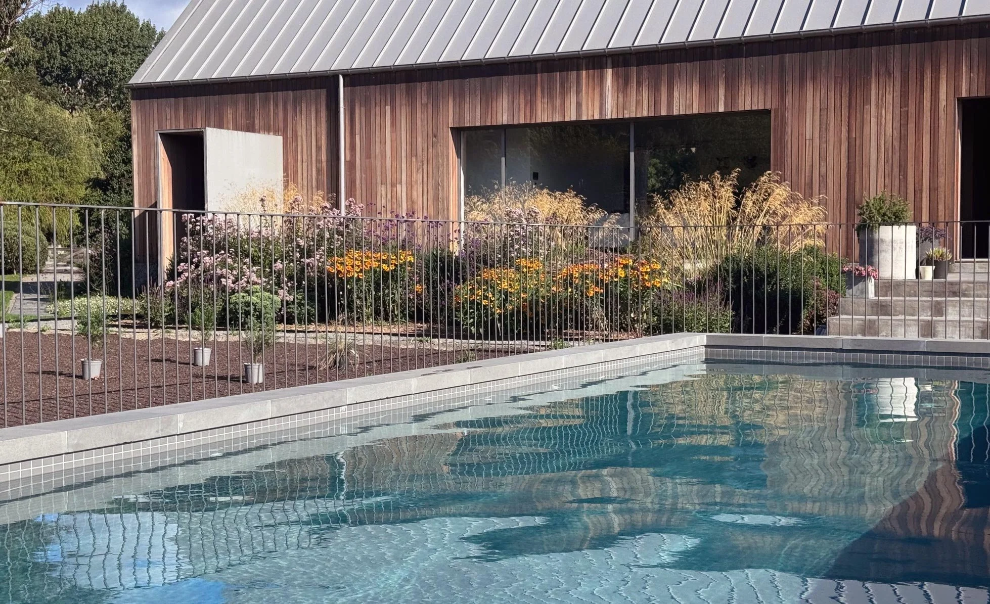 A swimming pool with pool fence, by Botanic Landscape Architects in Tai Tapu, Canterbury