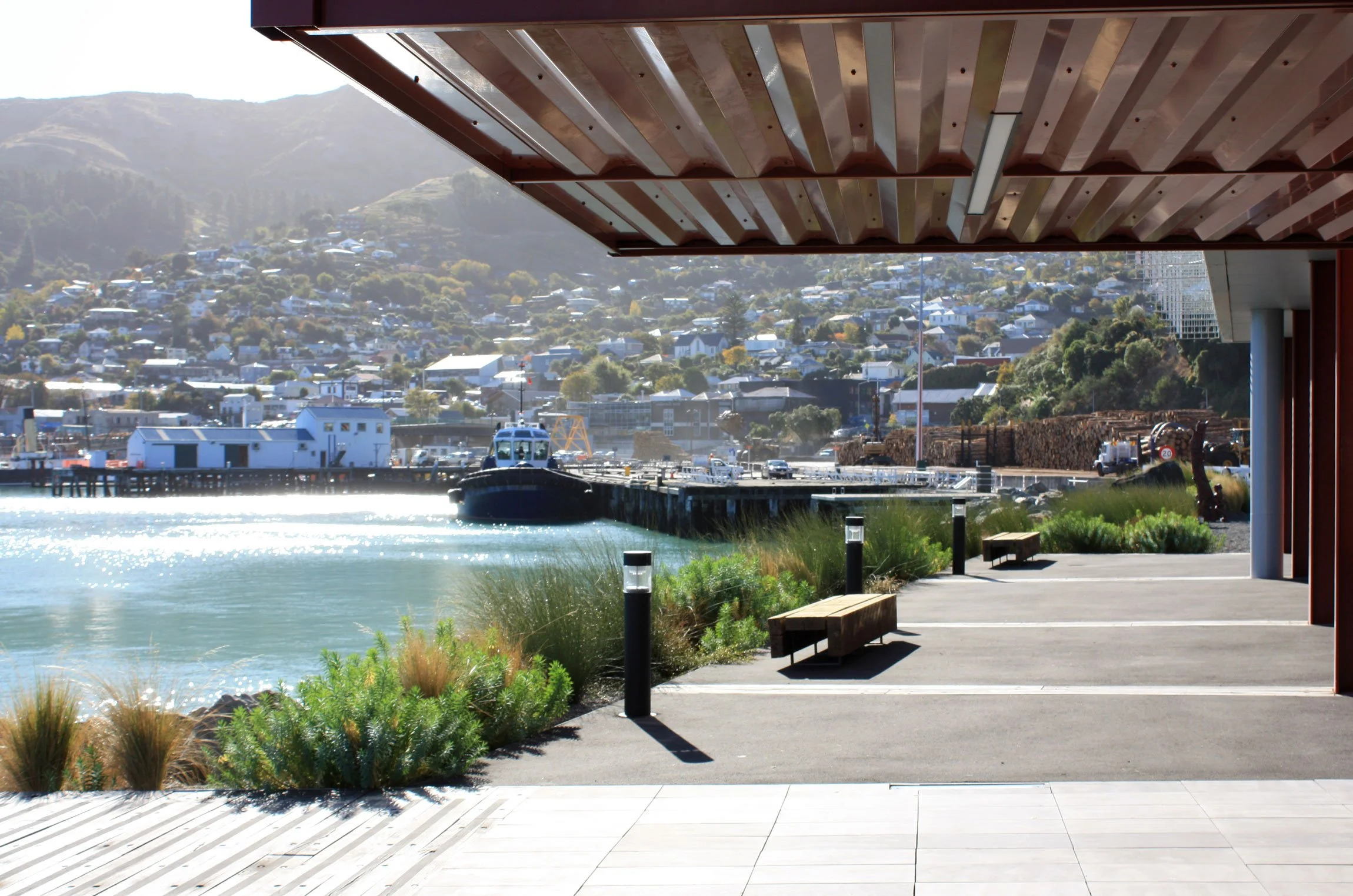 Pergola, bollards and benches integrated into waterfront terrace by Botanic Landscape Architects in Lyttelton, Christchurch