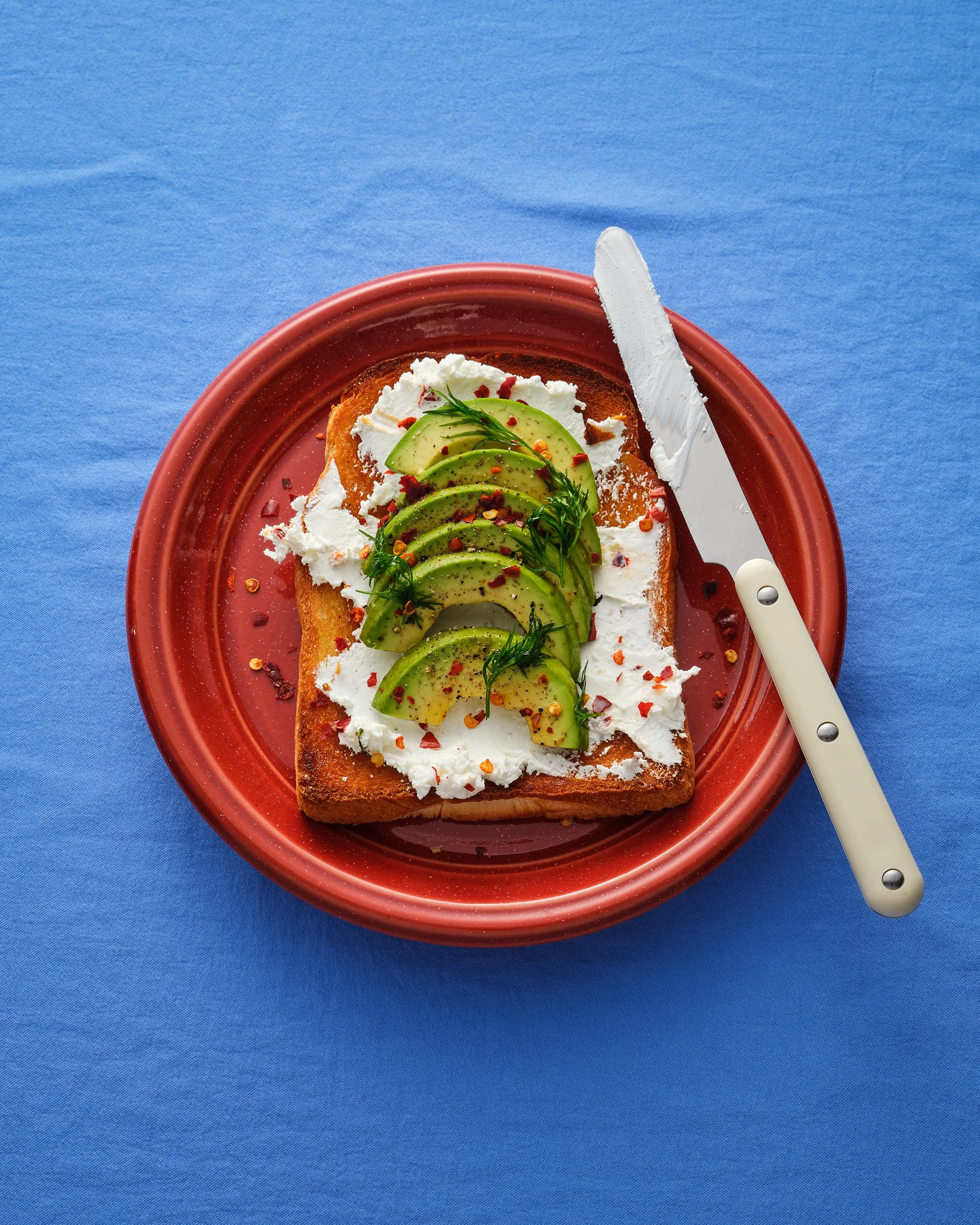 파란색 배경 위 아보카도 토스트 탑뷰(Top view) 촬영. 팝한 컬러감의 푸드 아트디렉팅.