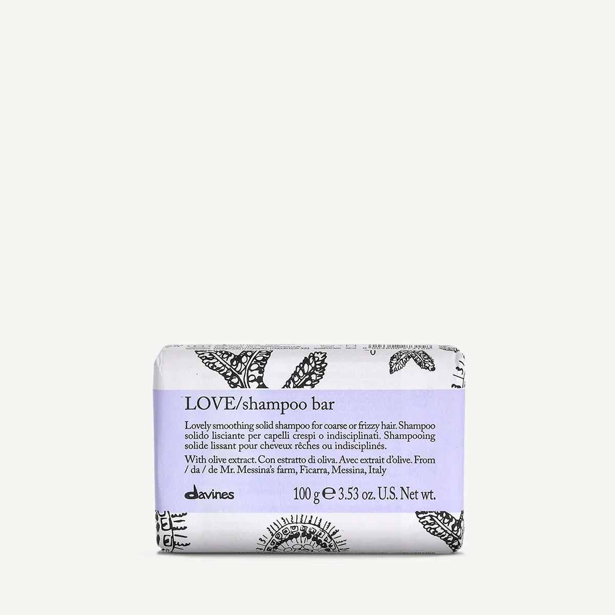 A bar of Love shampoo with olive extract, wrapped in white paper with black decorative illustrations, placed on a plain light background.