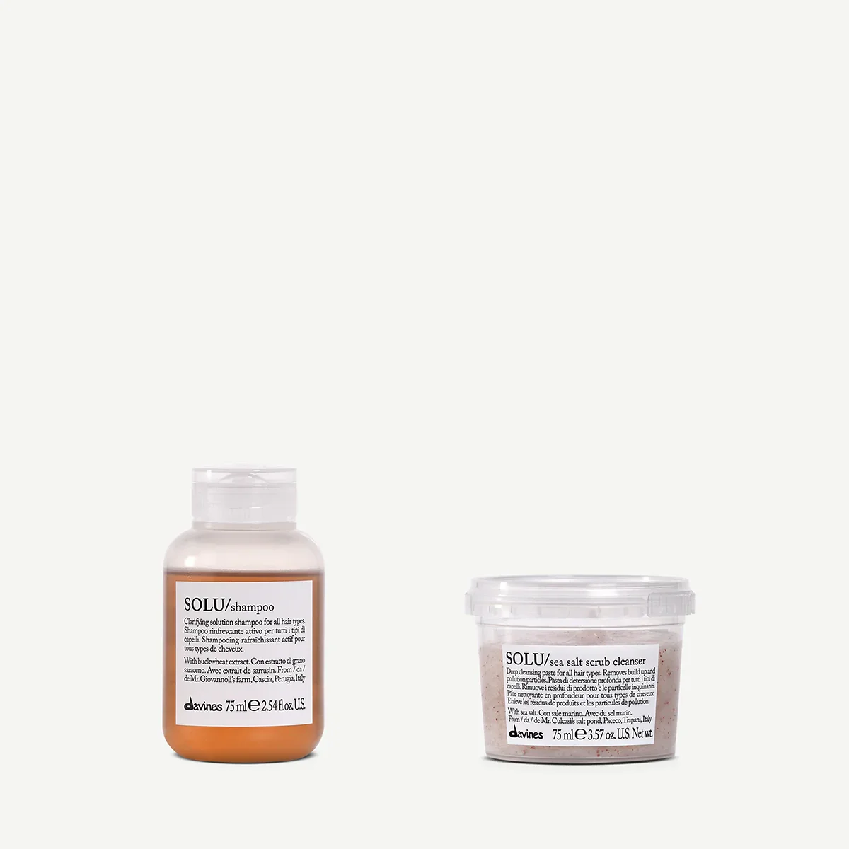 Two skincare products on a white background: a bottle of shampoo and a container of sea salt scrub cleanser.