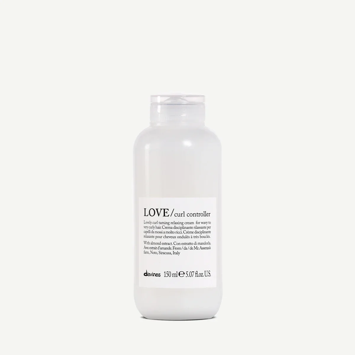 A white bottle of Love Curl Controller with a minimalist label, containing 150ml of cream for relaxing curly hair.
