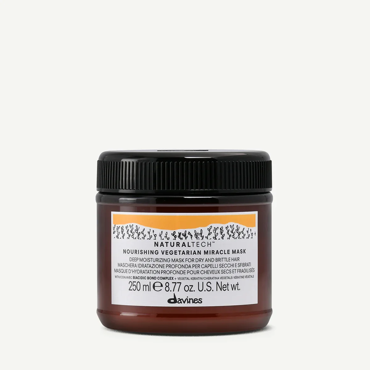 A jar of Nourishing Vegetarian Miracle Mask by Davines with black lid and white label with orange accents, containing deep moisturizing mask for dry and brittle hair.