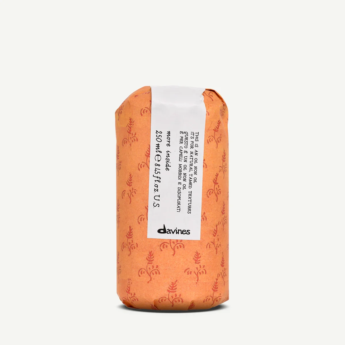 A canned product wrapped in orange paper with a white label containing product information and the brand name Davines.