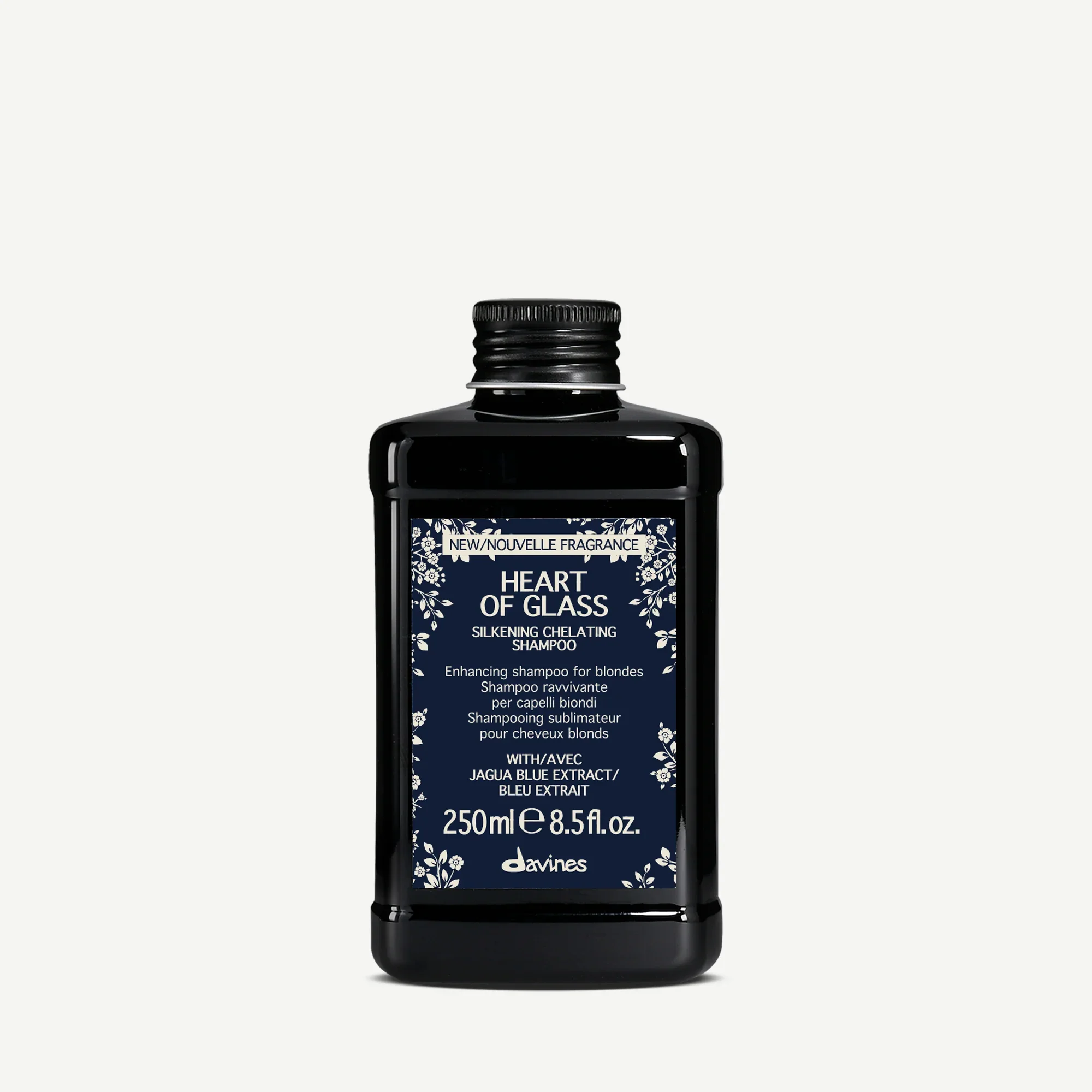A black bottle of Davines Heart of Glass Silkening Chelating Shampoo with a navy blue label featuring white floral designs and text, indicating a 250ml or 8.5 fl oz size.