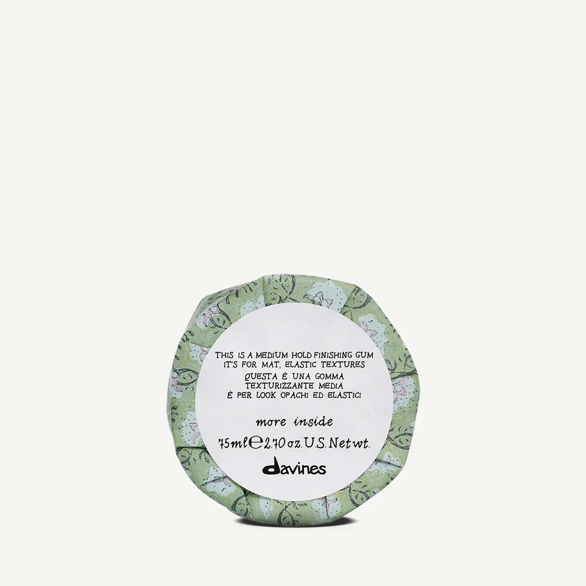 Small round container of Davines finishing gum with floral green and white patterned packaging, label indicates medium hold, elastic textures, 75ml.