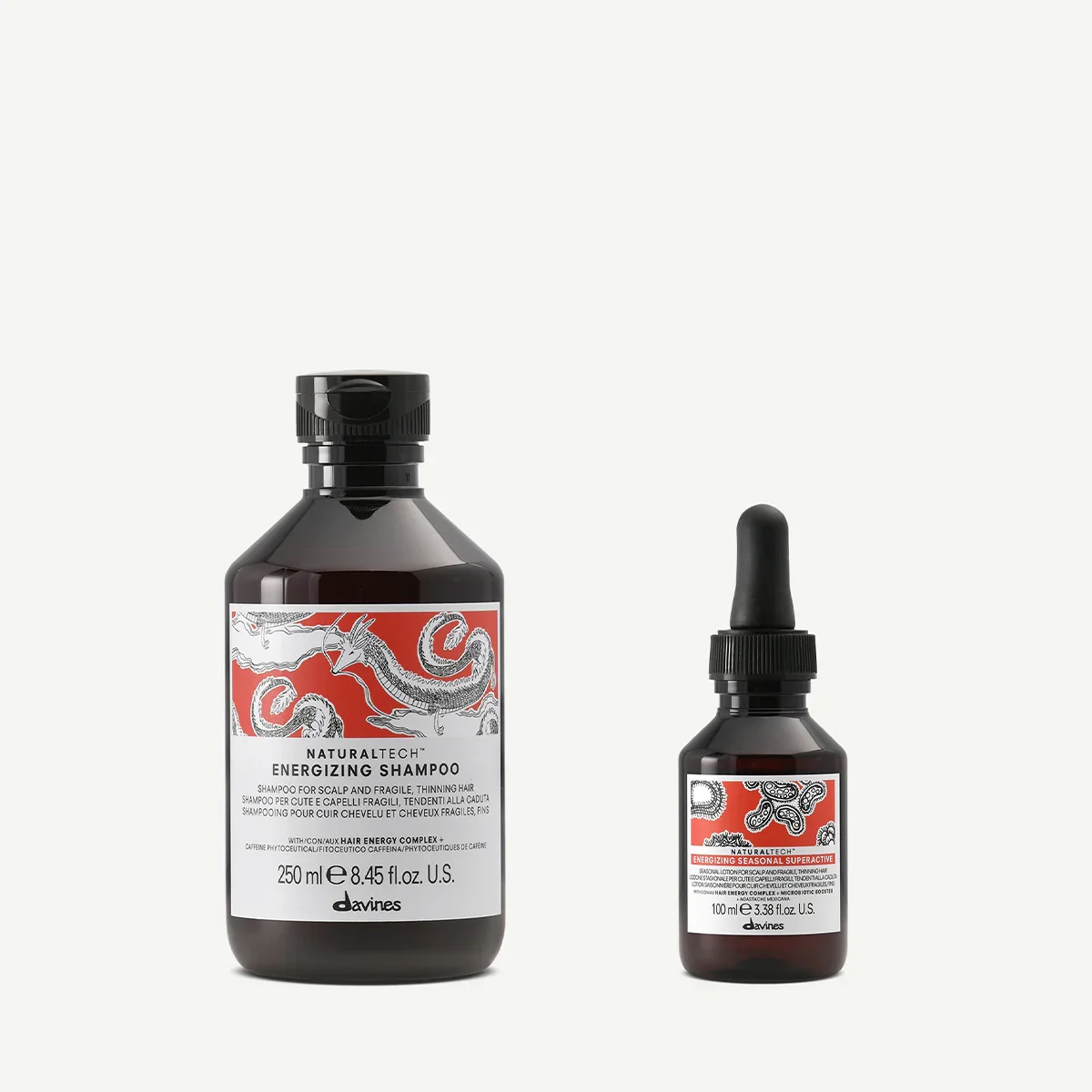 Two bottles of Davines hair care products: a larger bottle of energizing shampoo and a smaller bottle of energizing seasonal superactive with dropper.
